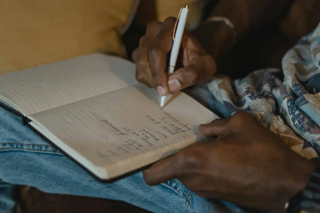 Hands holding a pen and notebook.