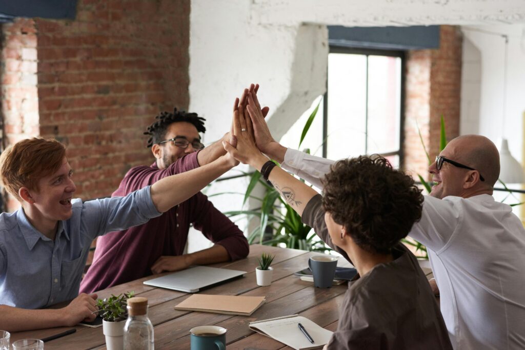 Coworkers high fiving across a table.